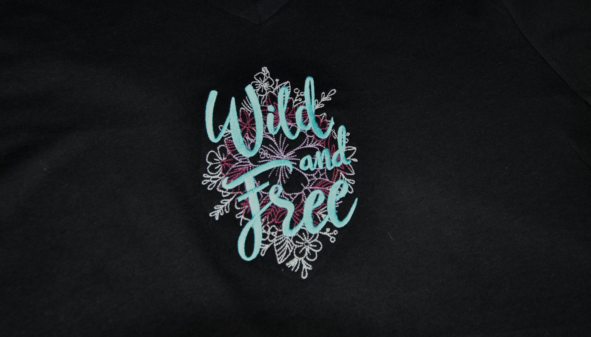 Embroidered patch with 'Wild and Free' text on a background of graphic flowers