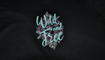 Embroidered patch with 'Wild and Free' text on a background of graphic flowers